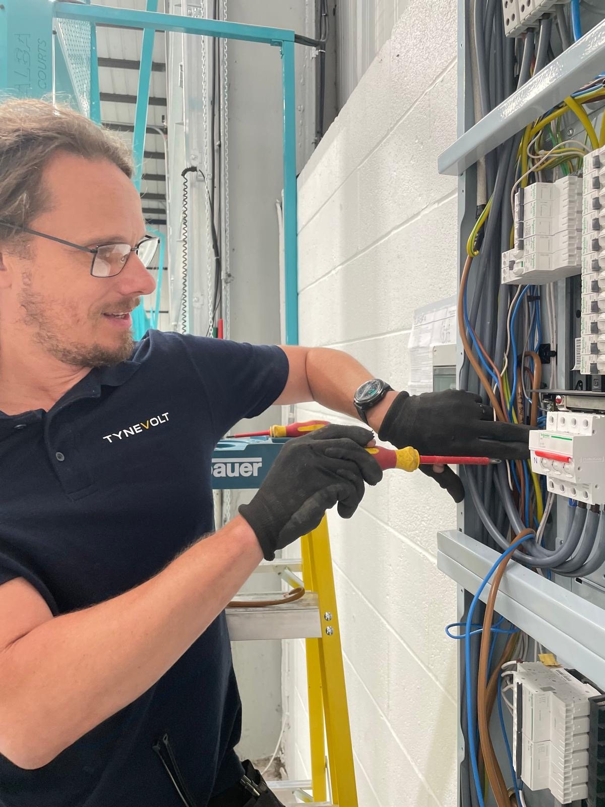 Andrew working at the electrical panel at Pikup Padel