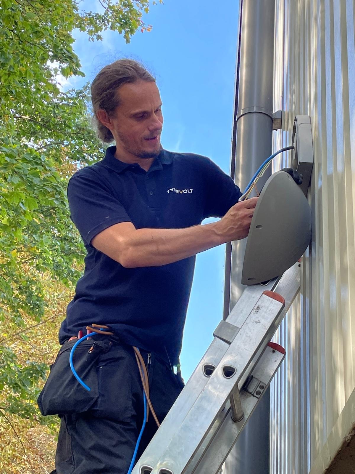 Andrew installing an exterior emergency light at Pikup Padel