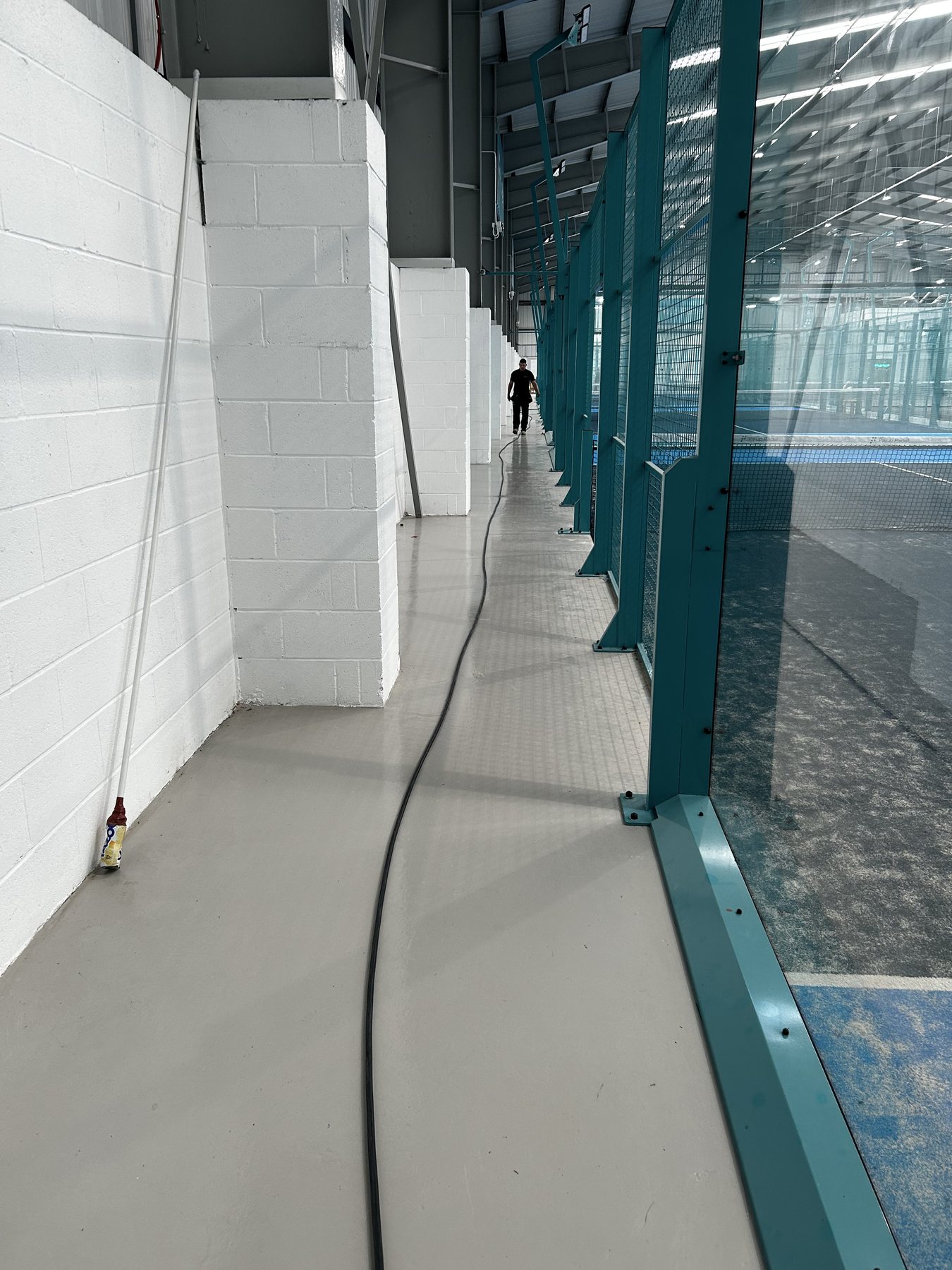 Cable laid along the walkway beside the padel courts