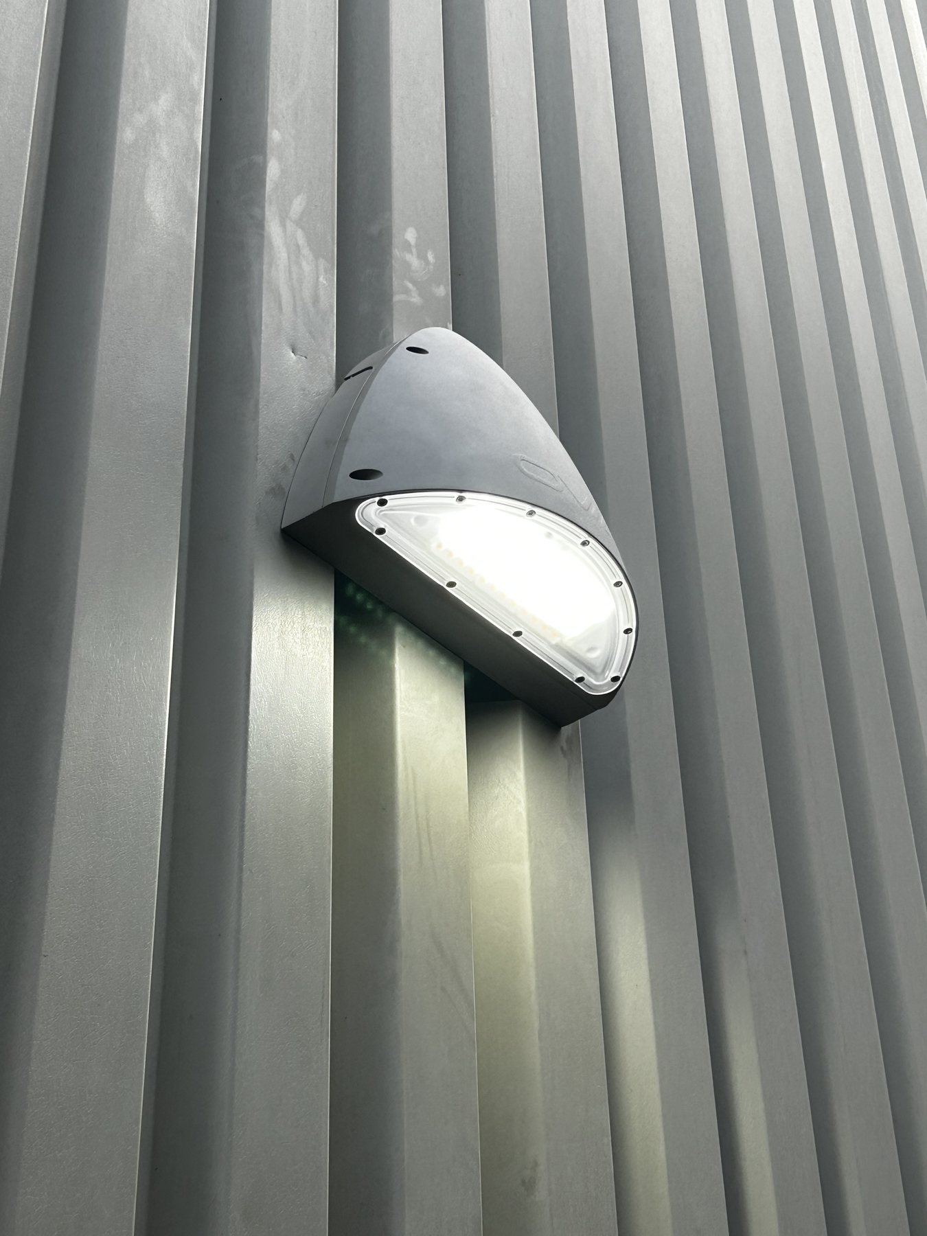 Close view of a lit emergency fitting on the exterior wall